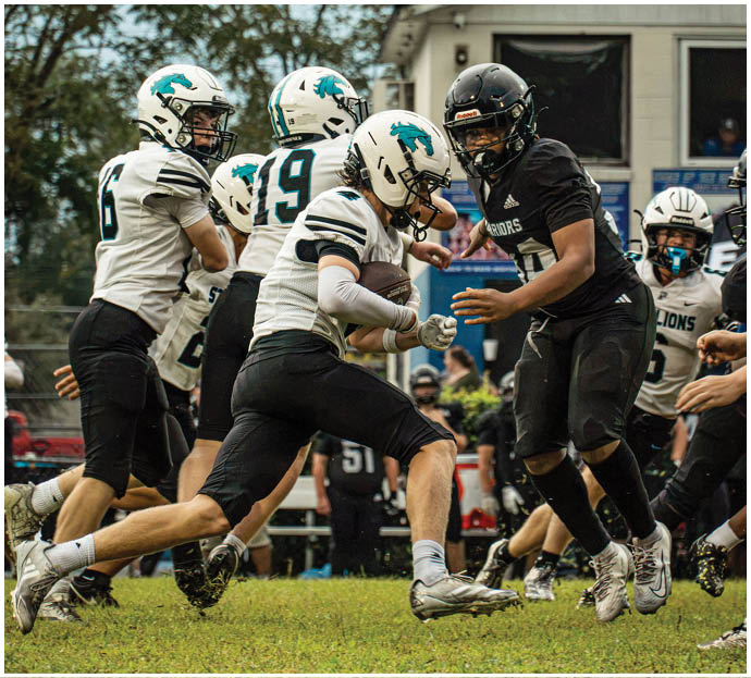 Three football players in blue and white uniforms running on a field. Description generated by AI