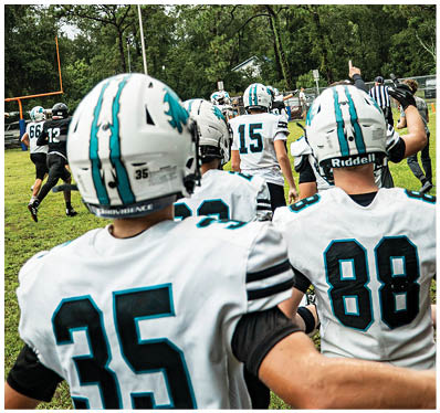 A group of football players on a field. Description generated by AI