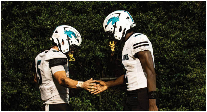 A group of football players on a field. Description generated by AI