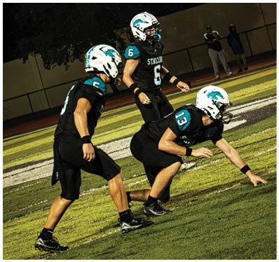 A group of football players on a field. Description generated by AI