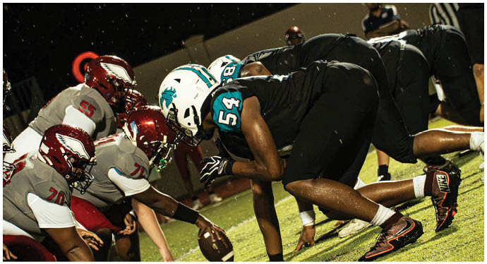 A group of football players on a field. Description generated by AI