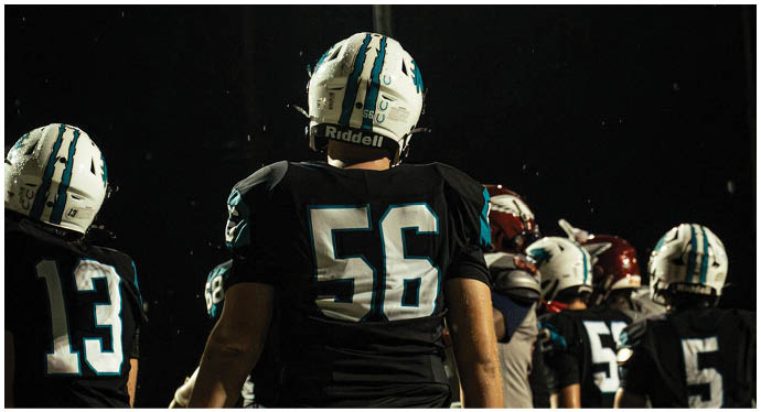 A group of football players on a field. Description generated by AI
