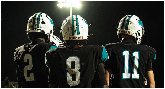 A group of football players on a field. Description generated by AI