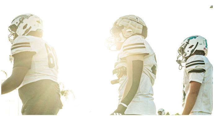 A group of football players on a field. Description generated by AI