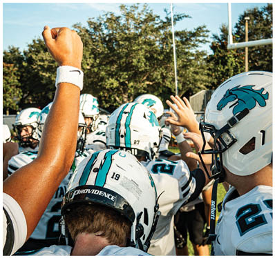 A group of football players on a field. Description generated by AI