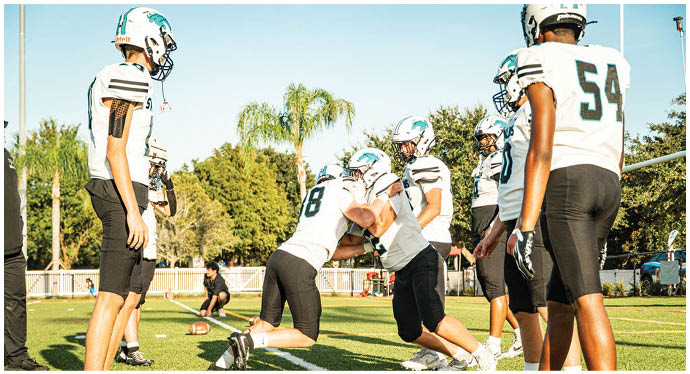A group of football players on a field. Description generated by AI