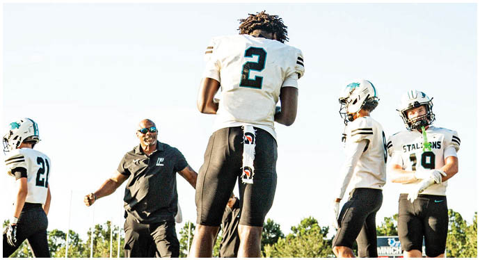 A group of football players on a field. Description generated by AI