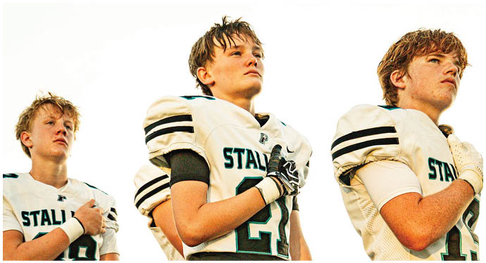 A group of football players on a field. Description generated by AI
