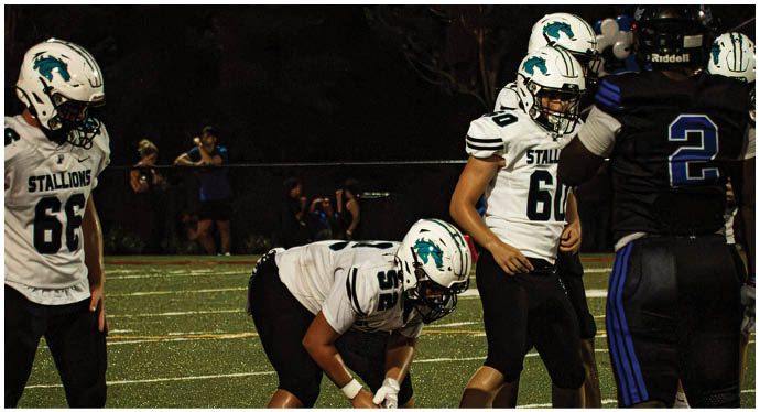 A group of football players on a field. Description generated by AI