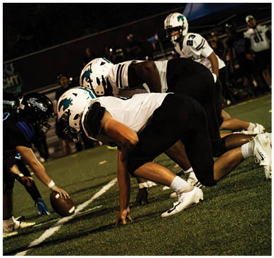 A group of football players on a field. Description generated by AI