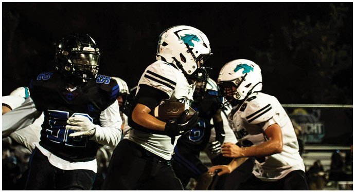 A group of football players on a field. Description generated by AI