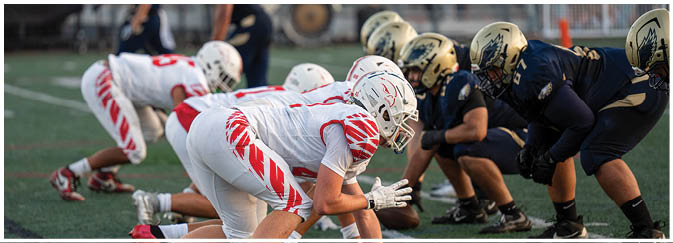 A football game is taking place on a field with players wearing blue and white uniforms. Description generated by AI
