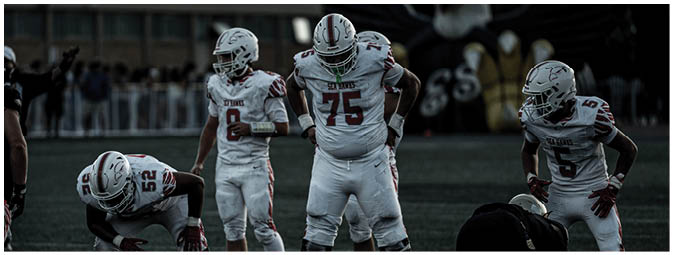 A group of football players on a field. Description generated by AI