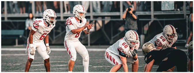 A group of football players on a field. Description generated by AI