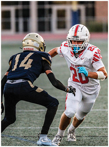 A football player wearing a blue and red jersey. Description generated by AI