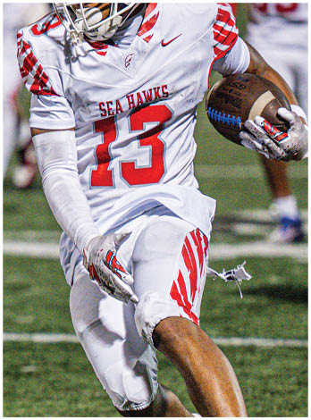 A football player wearing a blue and red jersey. Description generated by AI