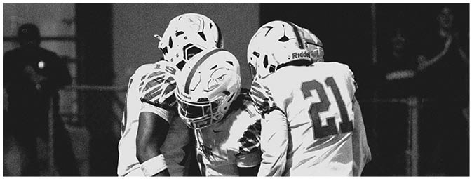 A group of football players on a field. Description generated by AI
