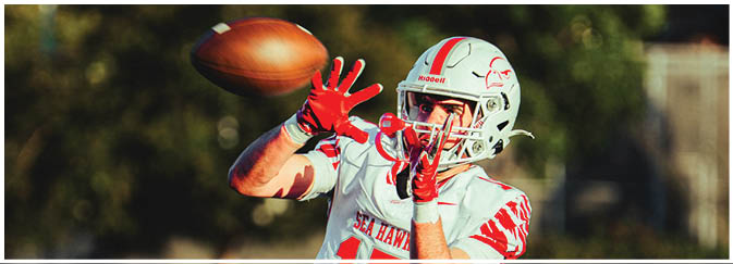 A football game is taking place on a field with players wearing blue and white uniforms. Description generated by AI