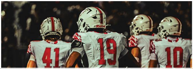 A football game is taking place on a field with players wearing blue and white uniforms. Description generated by AI