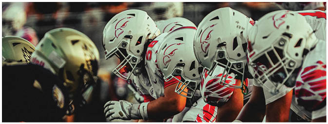 A group of football players on a field. Description generated by AI