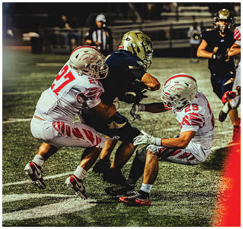 A football game is taking place with a group of men on the field. Description generated by AI