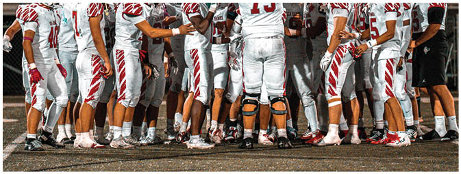 A group of football players on a field. Description generated by AI