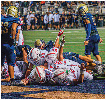 A football game is taking place with a group of men on the field. Description generated by AI