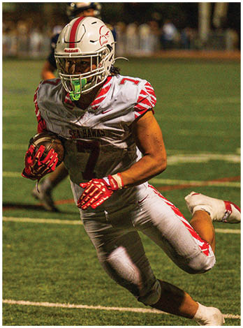 A football player wearing a blue and red jersey. Description generated by AI