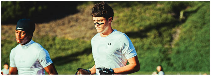 A football game is taking place on a field with players wearing blue and white uniforms. Description generated by AI