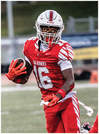 A football player wearing a blue and red jersey. Description generated by AI