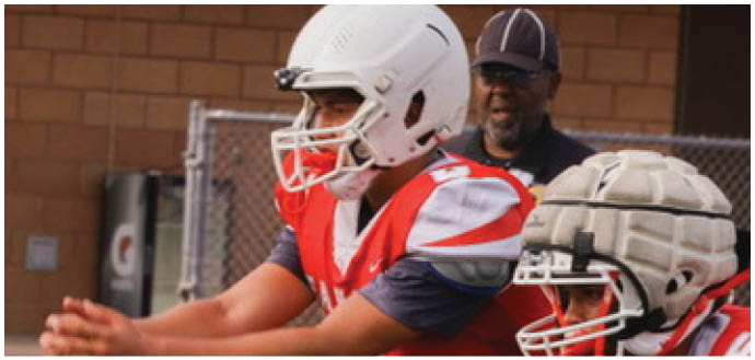 A football player wearing a blue and white uniform. Description generated by AI