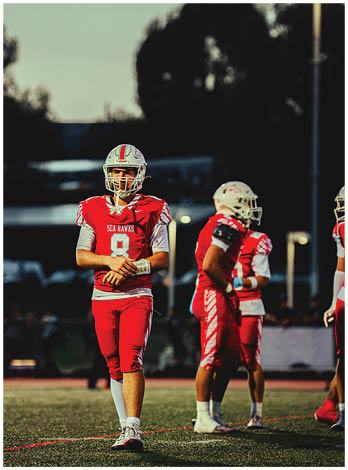A football player wearing a blue and red jersey. Description generated by AI