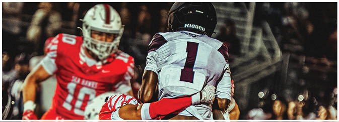 A football game is taking place on a field with players wearing blue and white uniforms. Description generated by AI