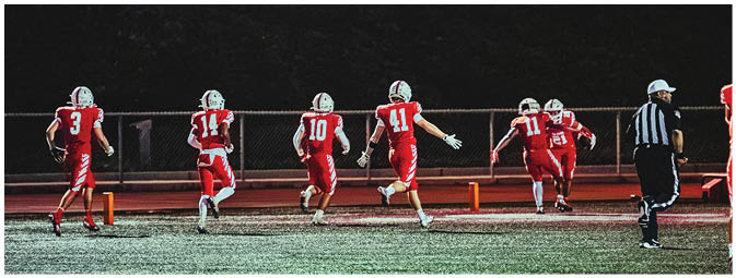 A group of football players on a field. Description generated by AI