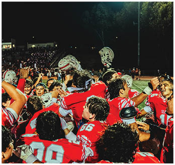 A football game is taking place with a group of men on the field. Description generated by AI