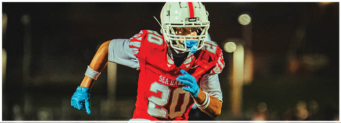 A football game is taking place on a field with players wearing blue and white uniforms. Description generated by AI