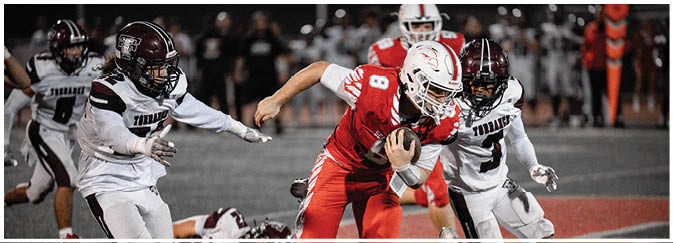 A football game is taking place on a field with players wearing blue and white uniforms. Description generated by AI