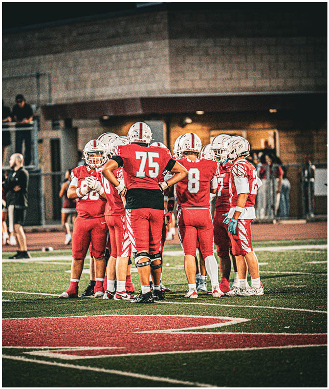 A group of football players on a field. Description generated by AI