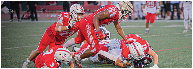 A football game is taking place on a field with players wearing blue and white uniforms. Description generated by AI