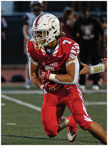 A football player wearing a blue and red jersey. Description generated by AI