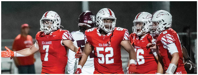 A group of football players on a field. Description generated by AI
