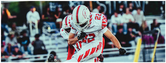 A group of football players on a field. Description generated by AI