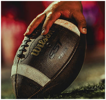A football game is taking place with a group of men on the field. Description generated by AI