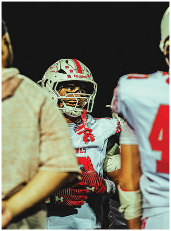 A football player wearing a blue and red jersey. Description generated by AI