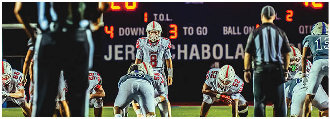 A football game is taking place on a field with players wearing blue and white uniforms. Description generated by AI