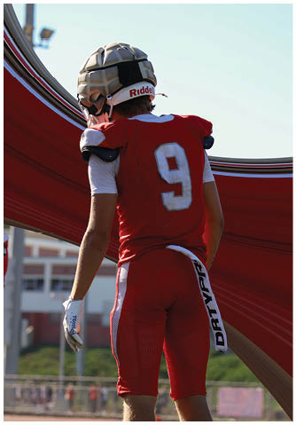A football player catching a ball. Description generated by AI