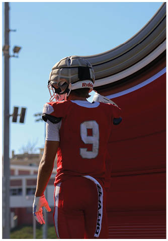A football player catching a ball. Description generated by AI