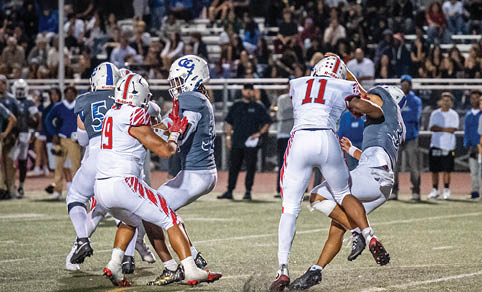 Two men wearing football uniforms are hugging each other on a field. AI generated content