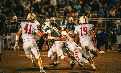 Two men wearing football uniforms are hugging each other on a field. AI generated content