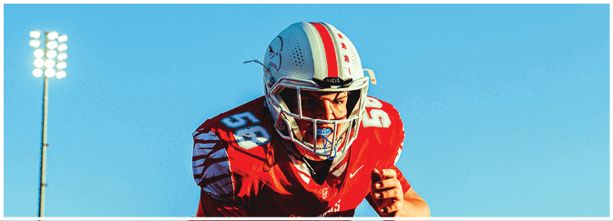 A football game is taking place on a field with players wearing blue and white uniforms. Description generated by AI
